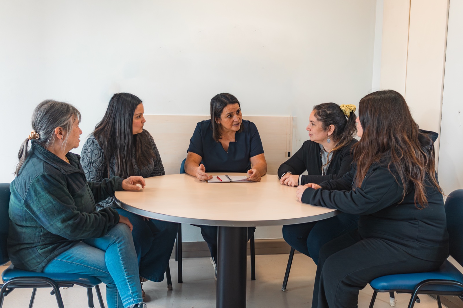 Ema Reyes conversando con un grupo en una mesa de acompañamiento